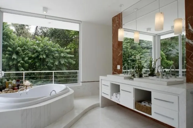 Banheira Elegance Oval instalada em banheiro com parede de mármore